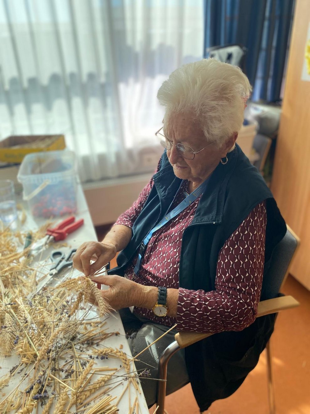 Eine Dame bindet Sträußerl.